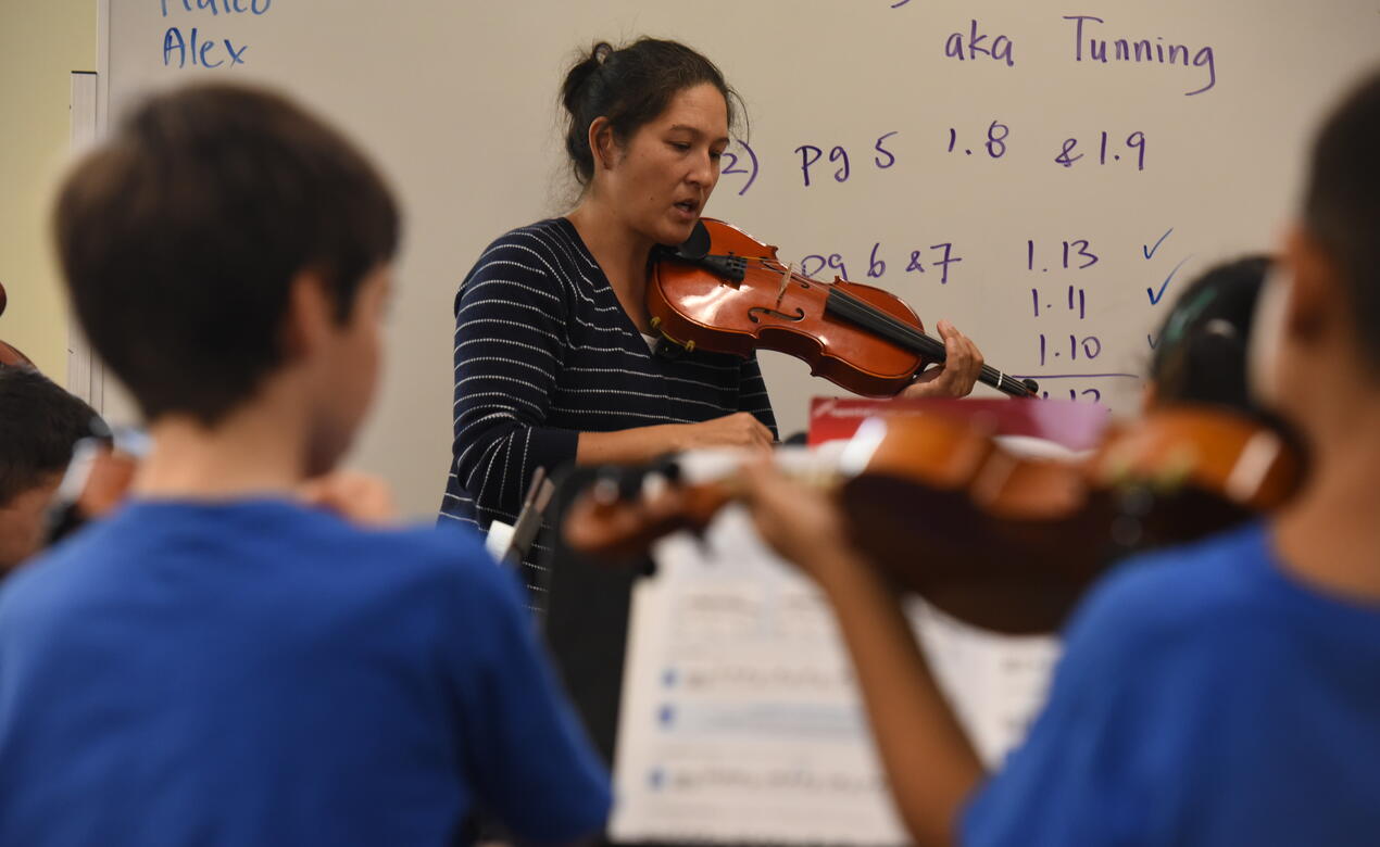A photo of Jennifer Fisher teaching Junior School strings