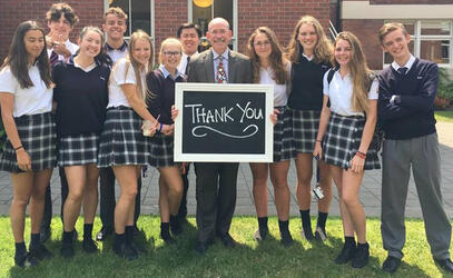 Andy Rodford holds a thank you sign with students