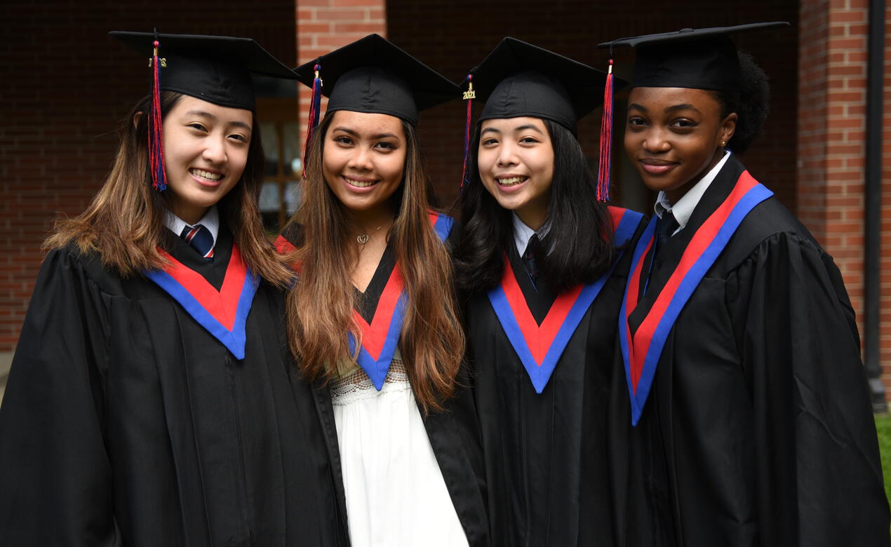 Four Grade 12 students in their graduation regalia