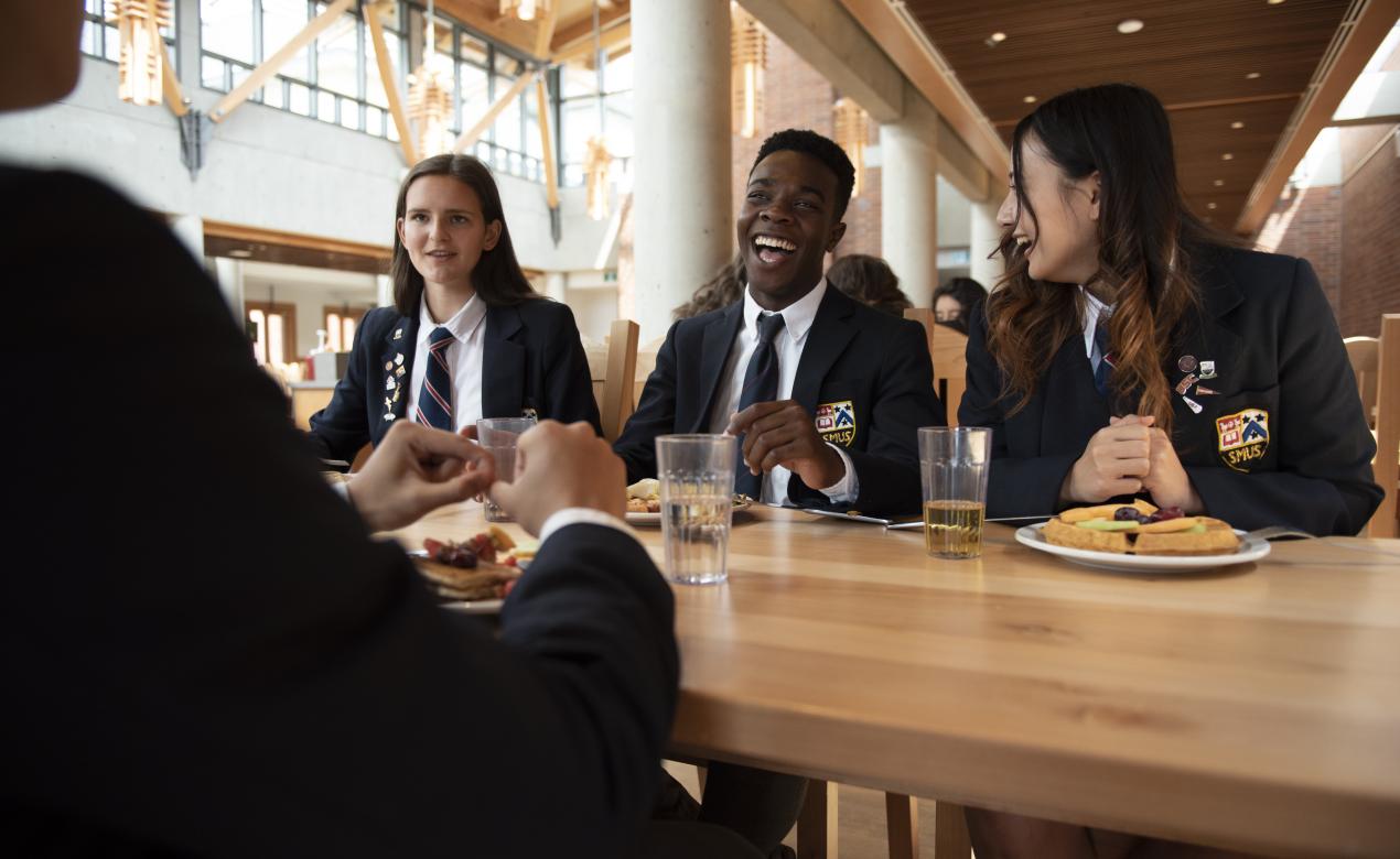 Senior School friends sharing a meal in the dining hall