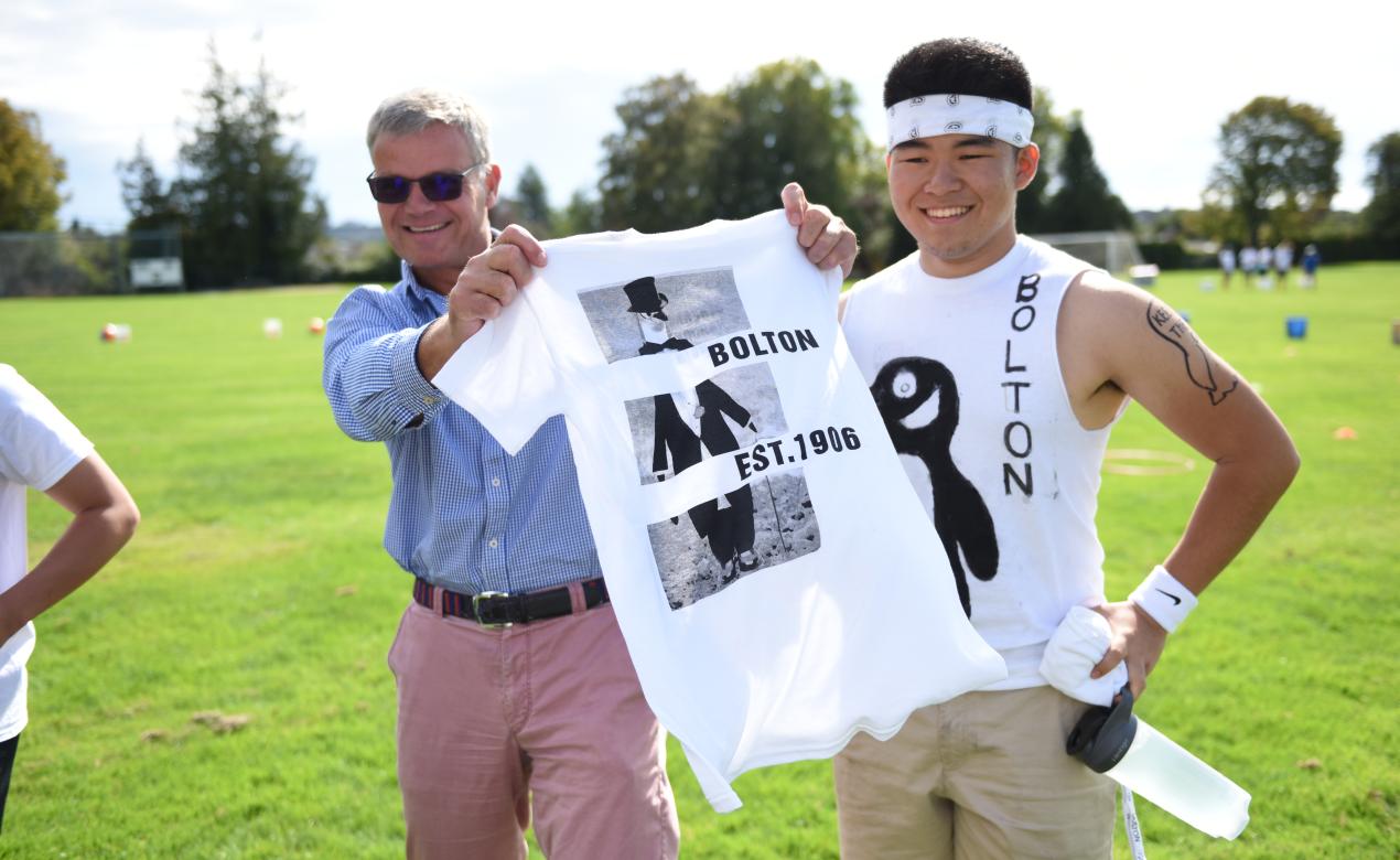 Mark Turner and student showing off Bolton house t-shirt