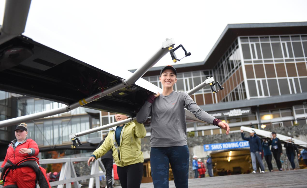 Senior School rowing athlete carrying a rowing shell