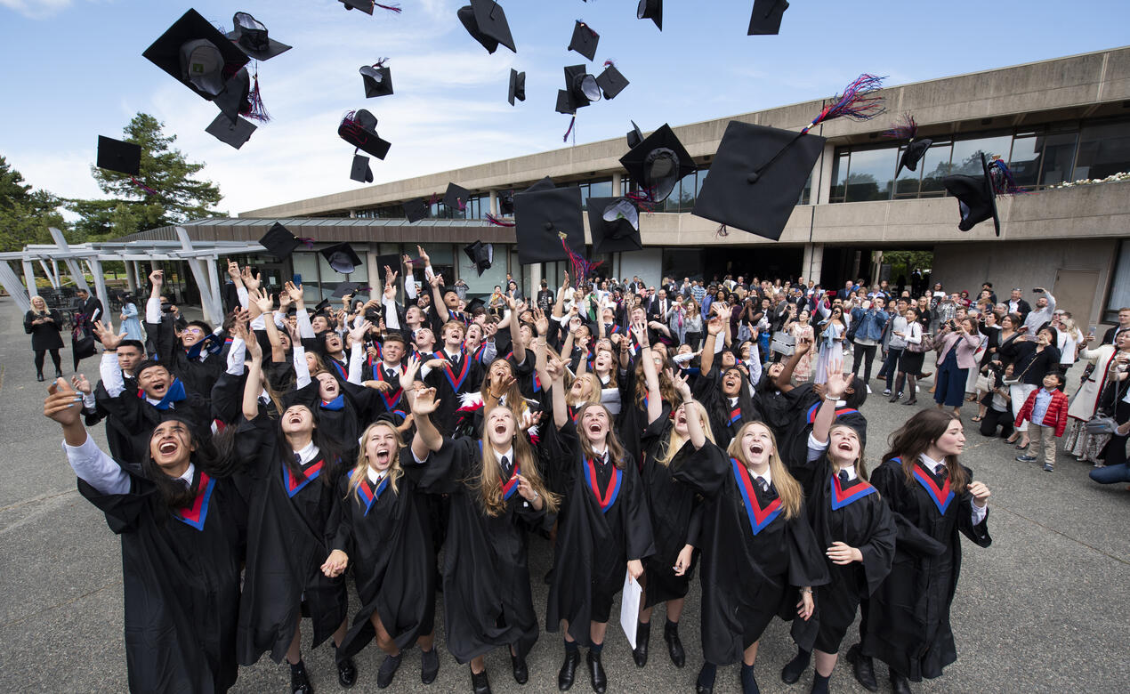 Grade 12 students throw their caps in the air to celebrate graduation.