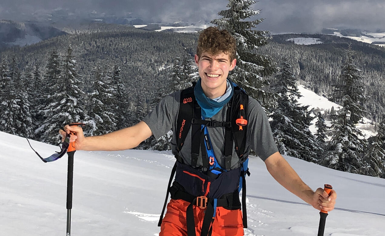 Alum Paul Mueller poses for a photo on a mountain while telemark skiing.