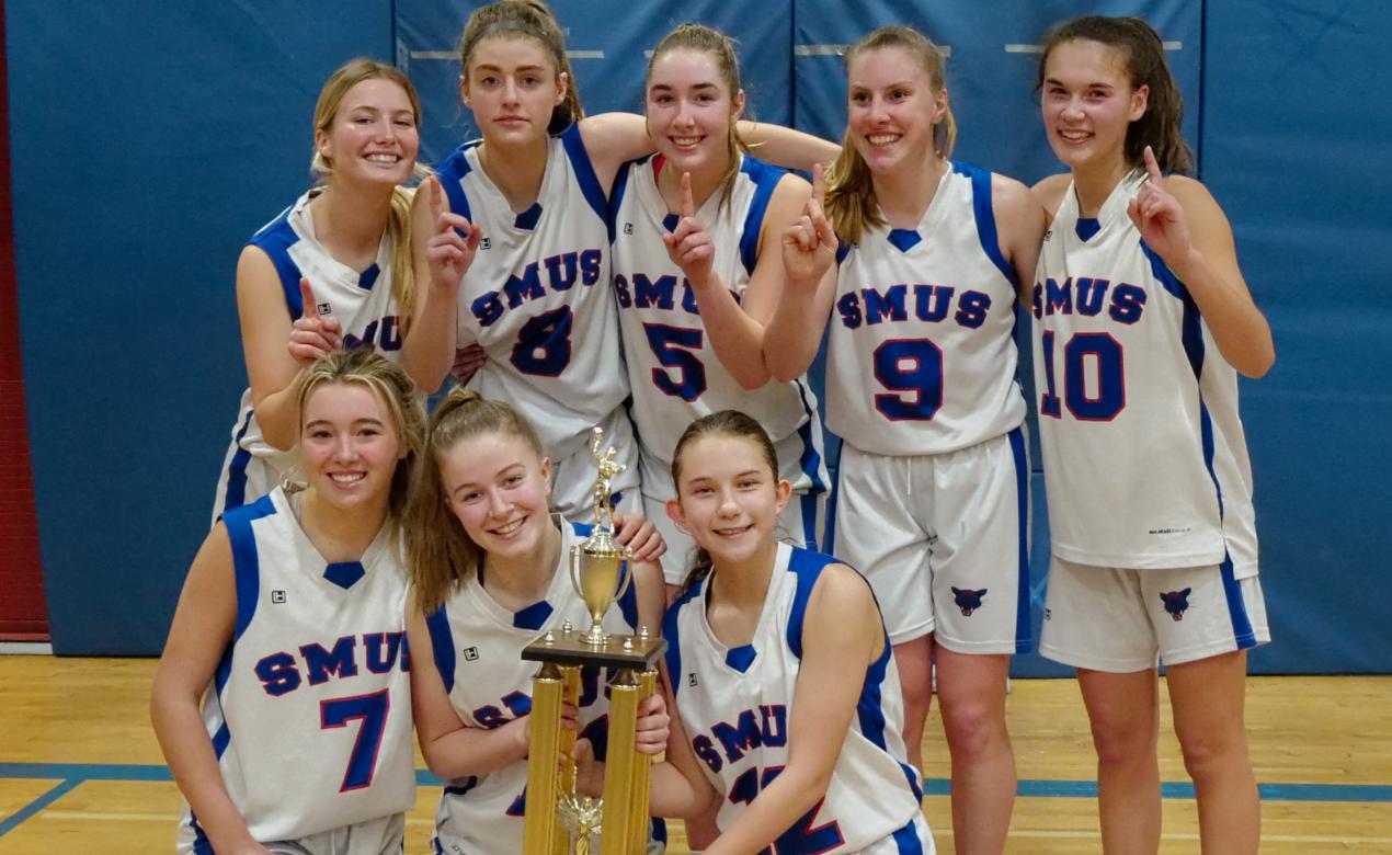 The Senior Girls Basketball team poses with the Island trophy.