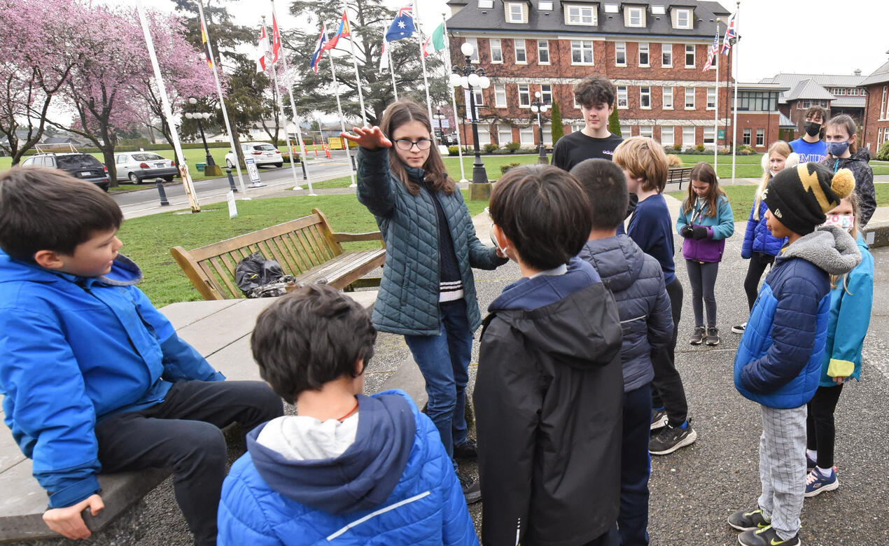 Teenage students work as camp counsellors with a group of young children.