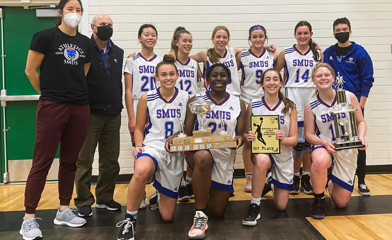 The Junior Girls Basketball team poses with the Island trophy.