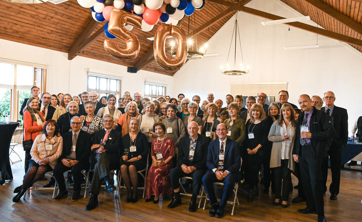 A large group of retired SMUS faculty and staff pose together for a photo in Brown Hall.