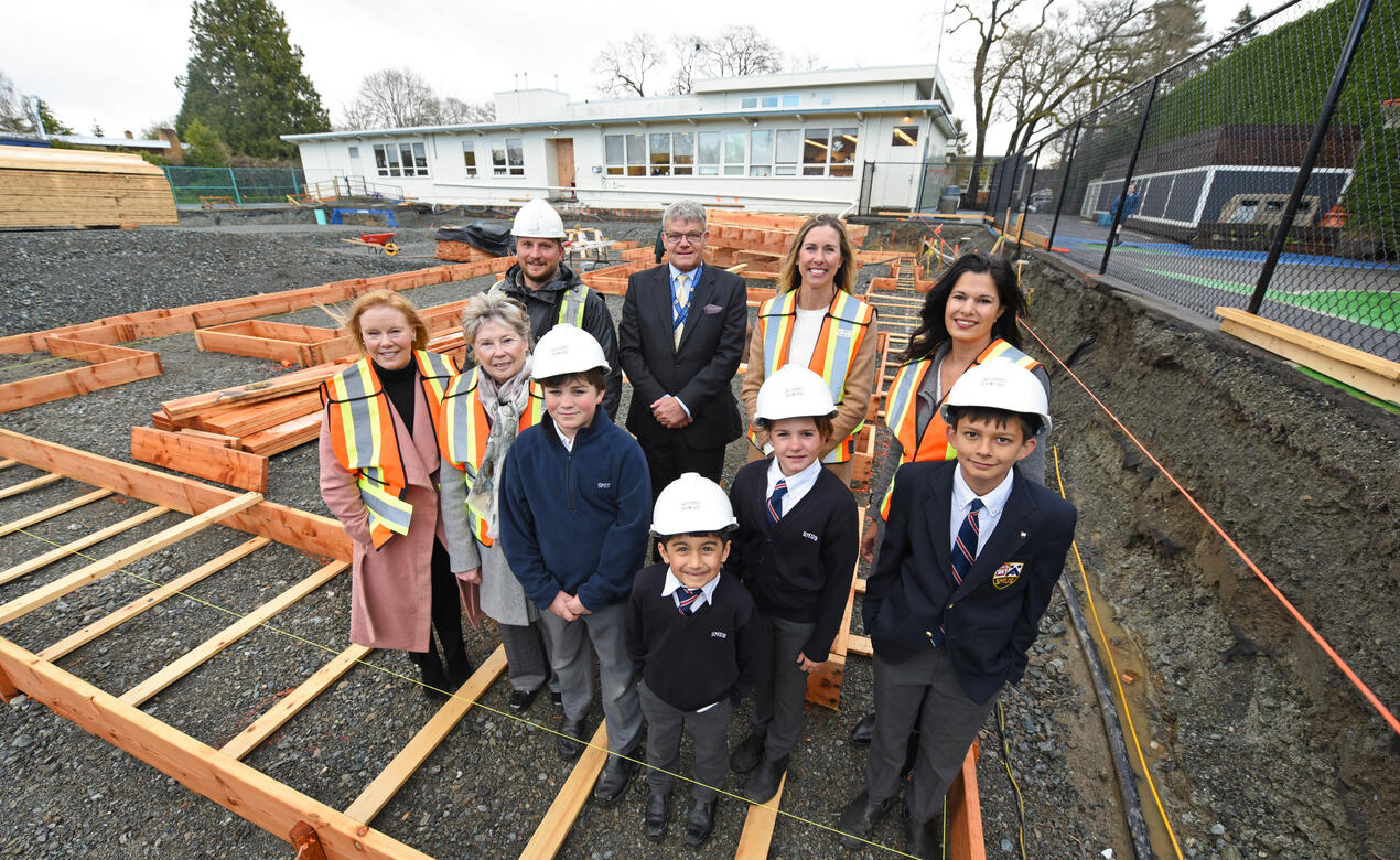 A group of SMUS community members stand in the Junior School Annex construction site