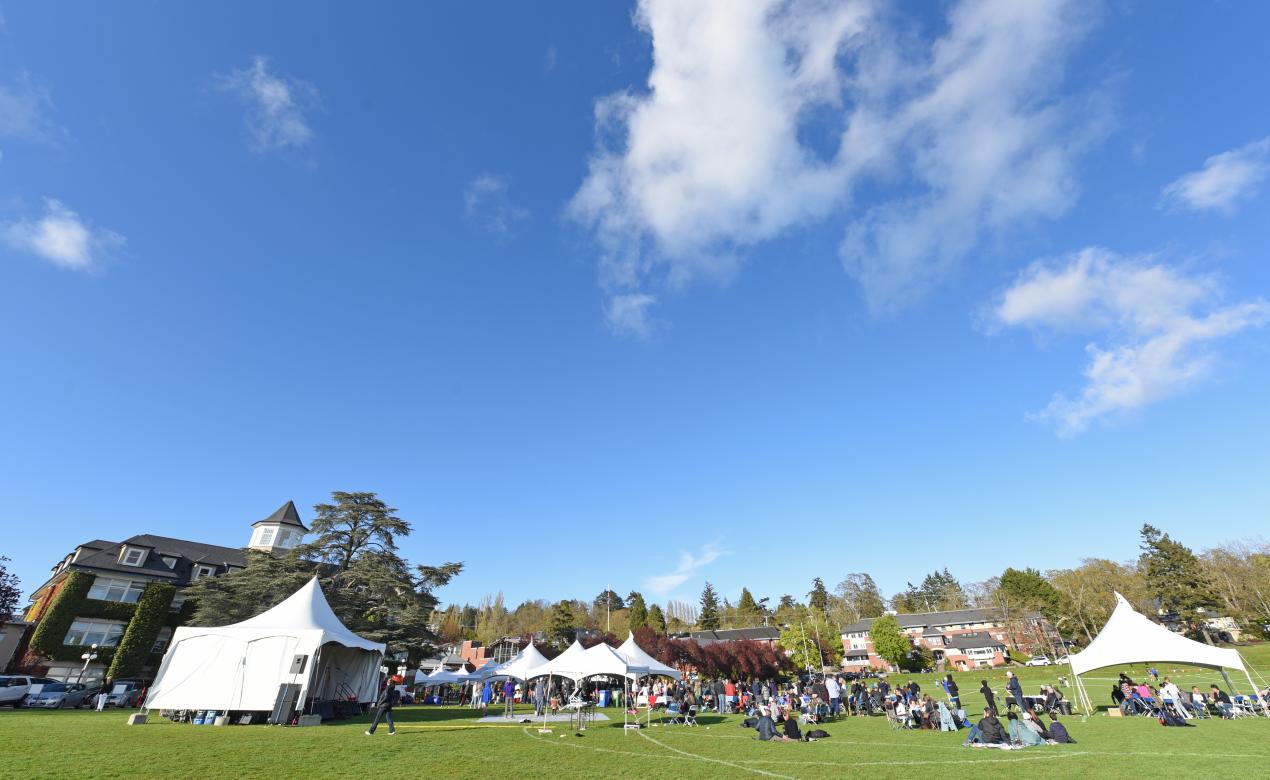 A wide photo of the SMUS campus at Alumni Weekend featuring tents and crowds.