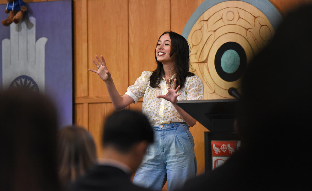 Alumna Ann Makosinski '15 stands on a stage in the SMUS Chapel and talks to a crowd