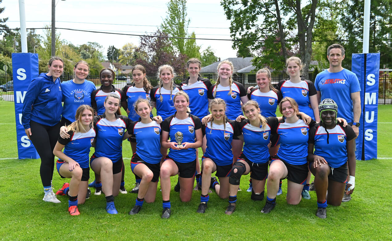 The Senior Girls Rugby team poses with a trophy after the final of the 2021-22 Island championships.