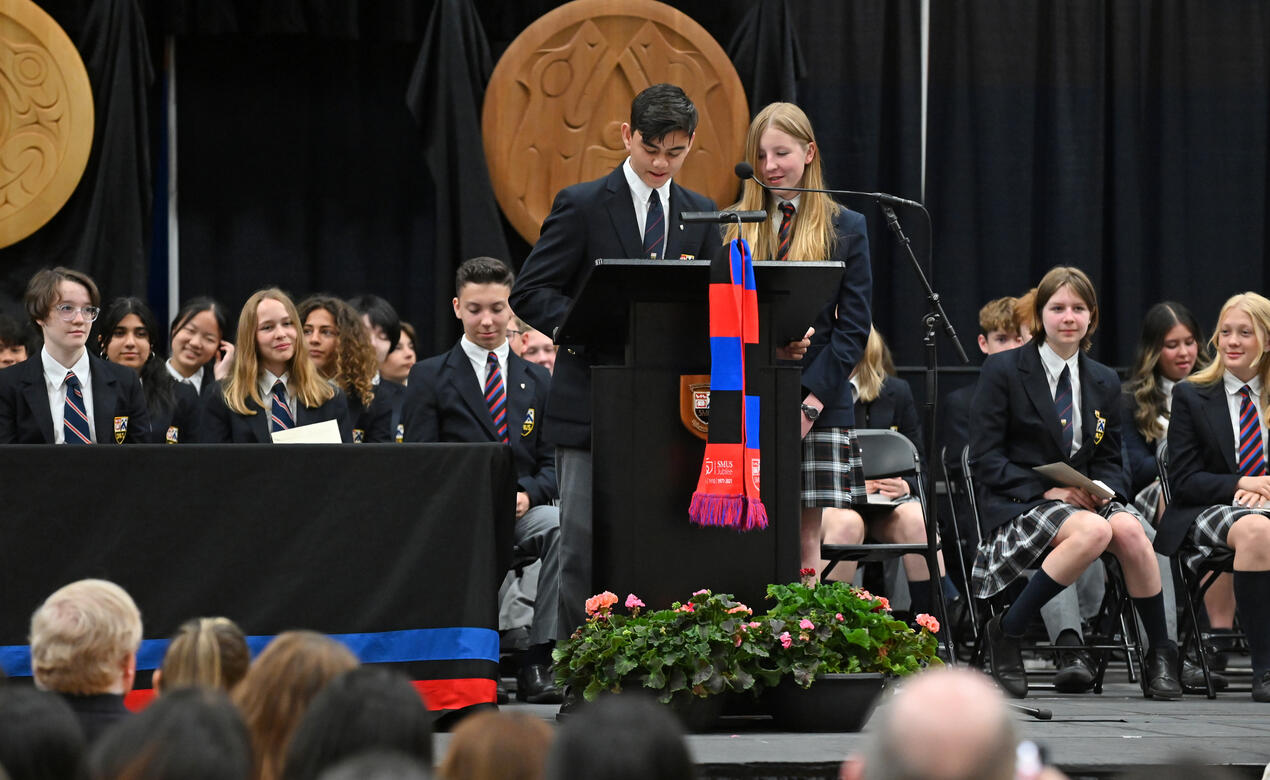 Grade 8 students Matthew and Samantha stand on stage together during the Closing Ceremony and deliver a speech in front of a large crowd.