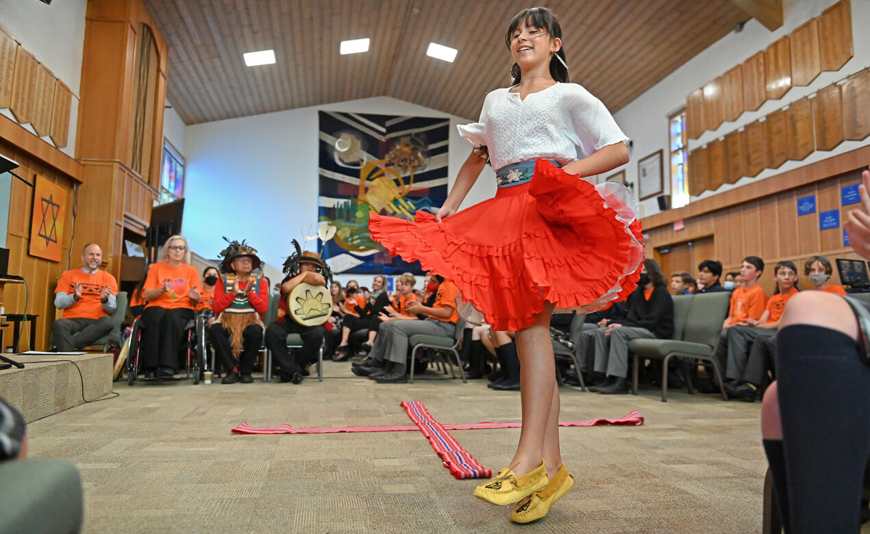 A student performs a Metis sash dance in the chapel during the Middle School's National Day for Truth and Reconciliation ceremony