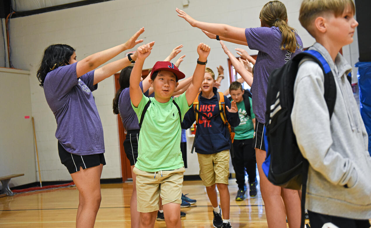 A Middle School student cheers and they enter the gymnasium as part of the WEB Welcome event