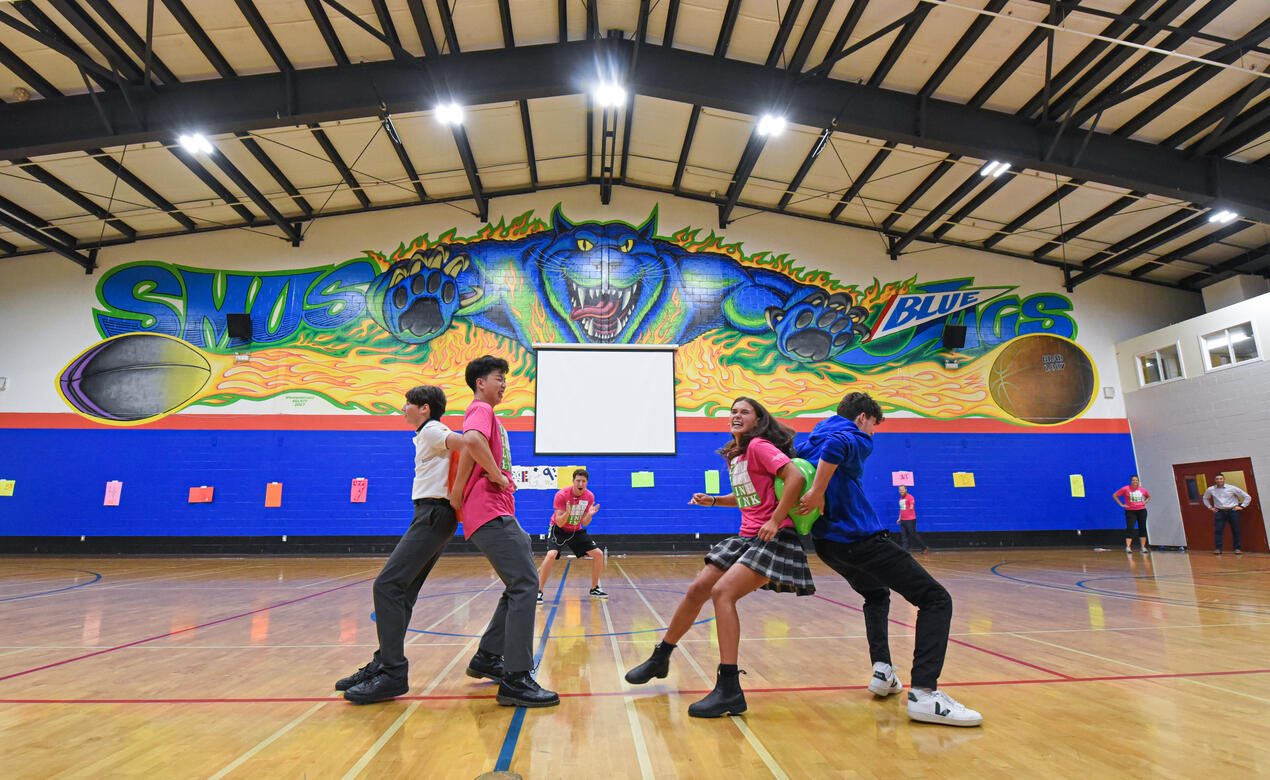 Senior School Link Leaders lead a balloon game by trying to pop a balloon alongside new students