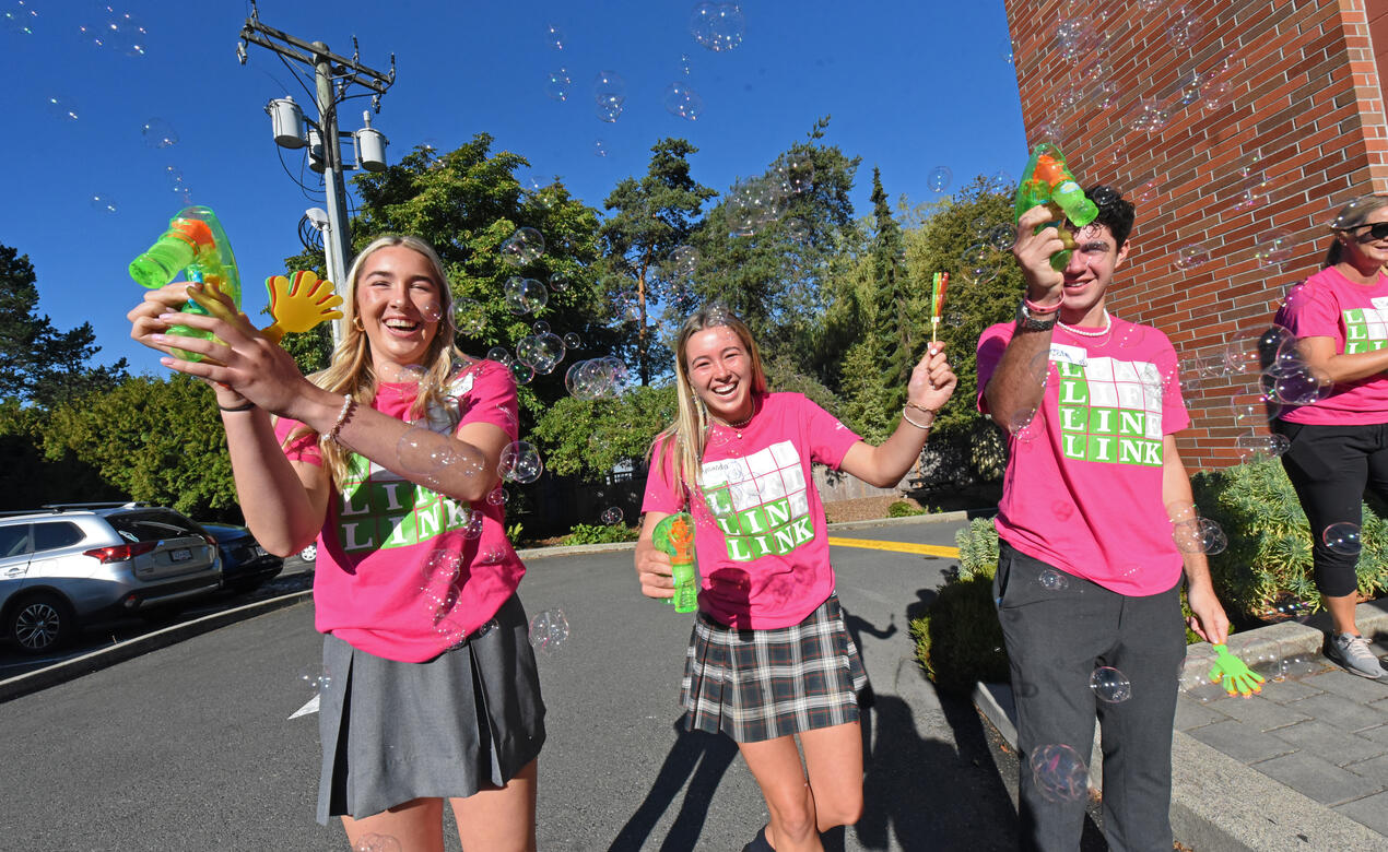 Three Grade 12 Link Leaders blow bubbles to celebrate the start of the new school year