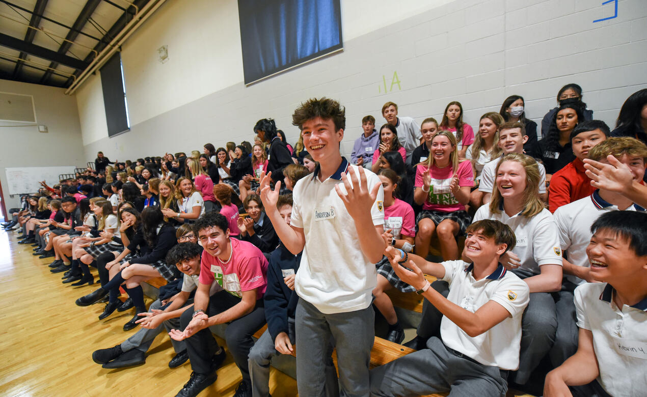 A Senior School student reacts to being selected for a game while a crowd around them smiles and cheers.