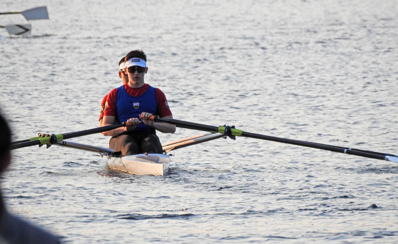 Two athletes in a double scull row on choppy waters