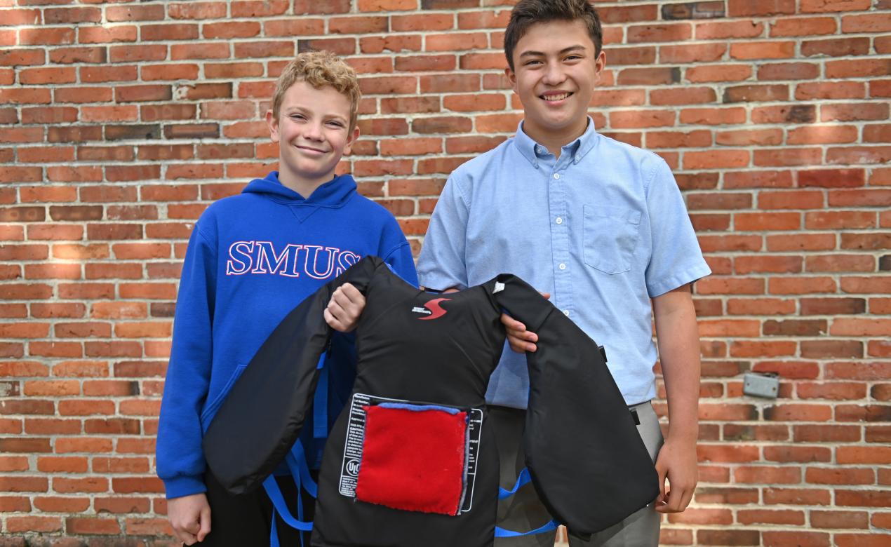 Two Grade 8 students show off a life vest that has their LifeHeat invention on it.