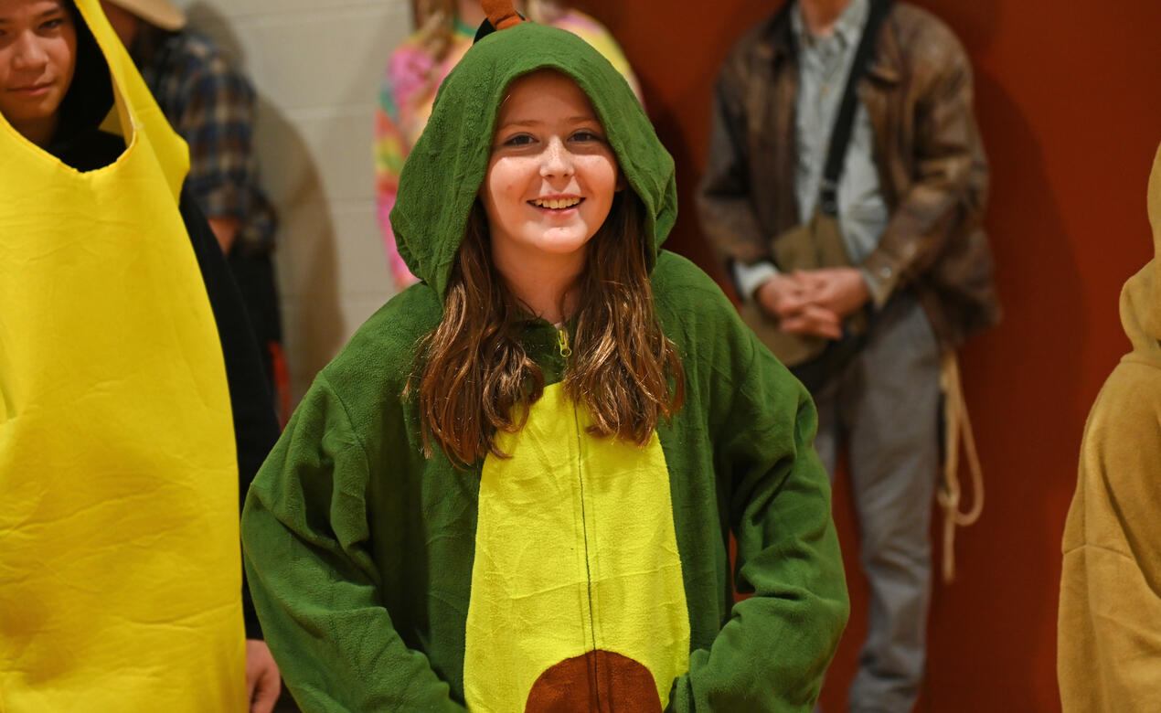 A student dressed as an avocado smiles