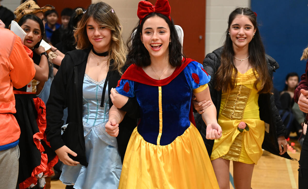 A trio of students in colourful dresses at Halloween