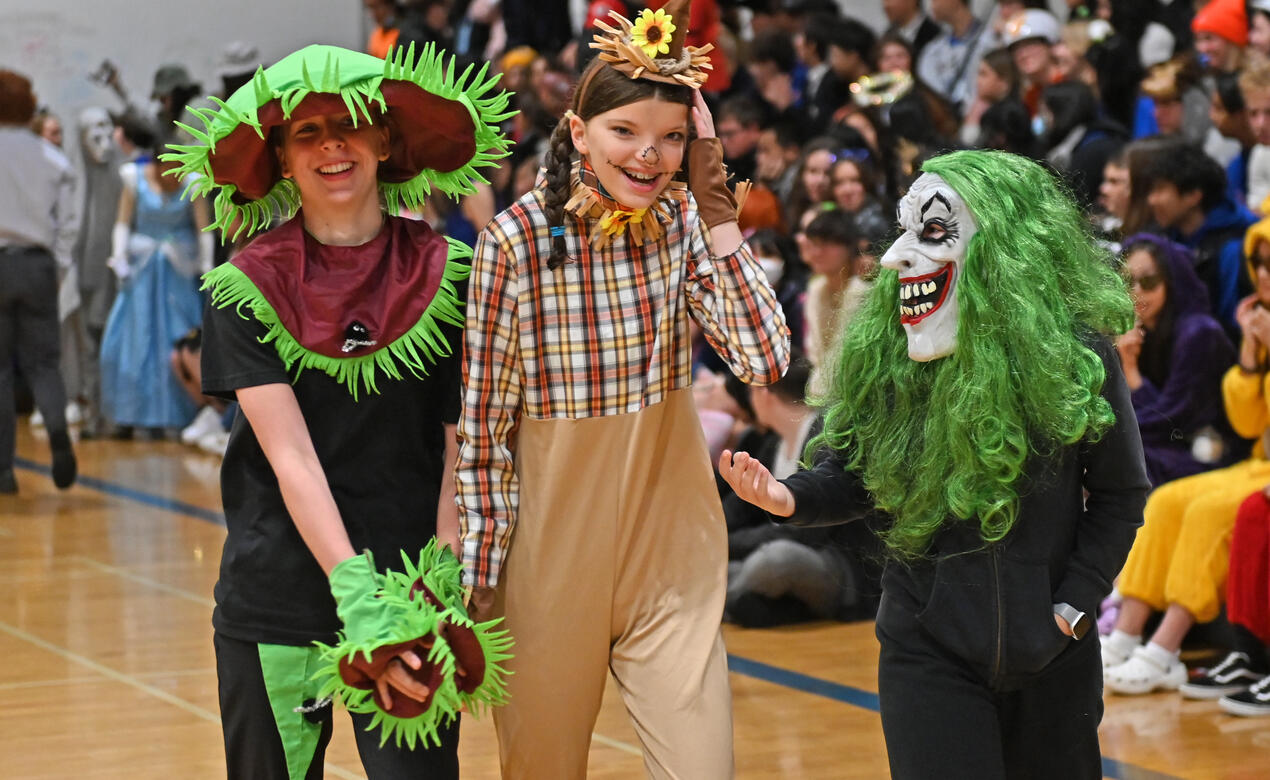 A trio of students, dressed as a venus flytrap, a scarecrow and a scary clown, at Halloween.