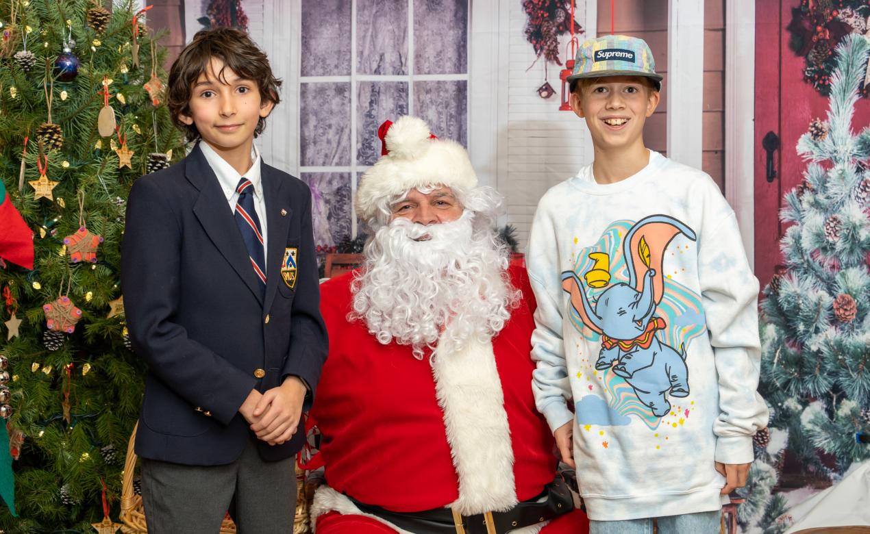 A pair of students pose for a photo with Santa