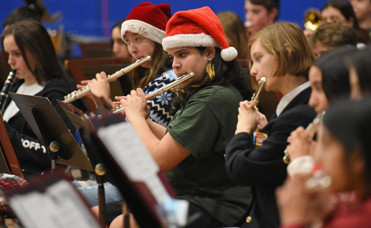 Middle School flautists perform while wearing Santa hats