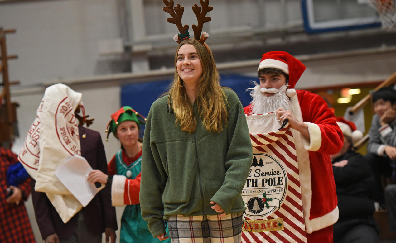 A student dressed as a reindeer gets sneakily followed by a student dressed as Santa during the All School Christmas Assembly