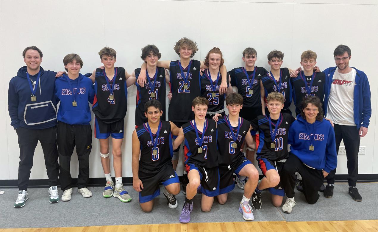 The Junior Boys Basketball team poses with the ISA trophy.