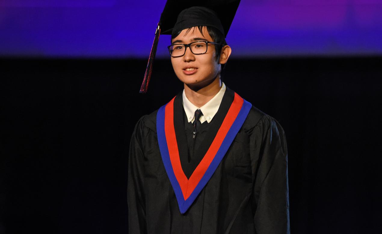 A photo of alumnus Alikhan Seisembekov at the graduation ceremony