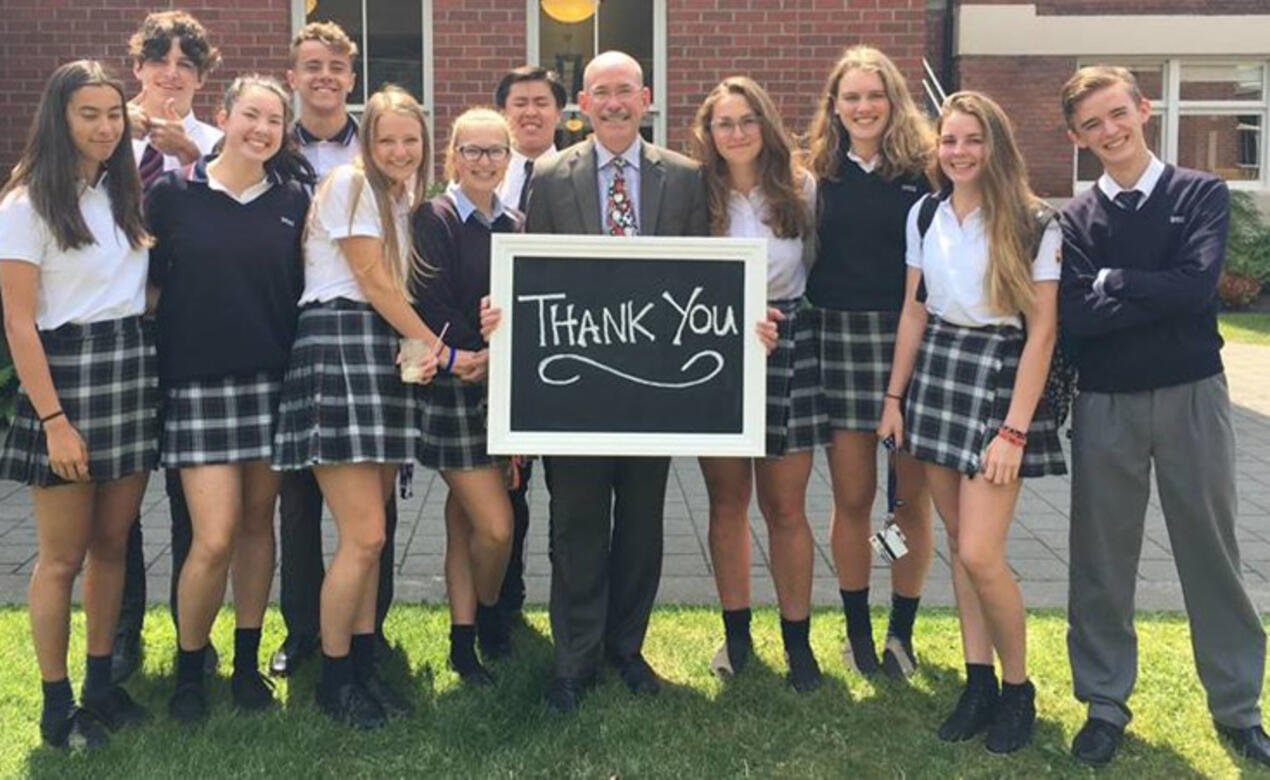 Andy Rodford holds a thank you sign with students
