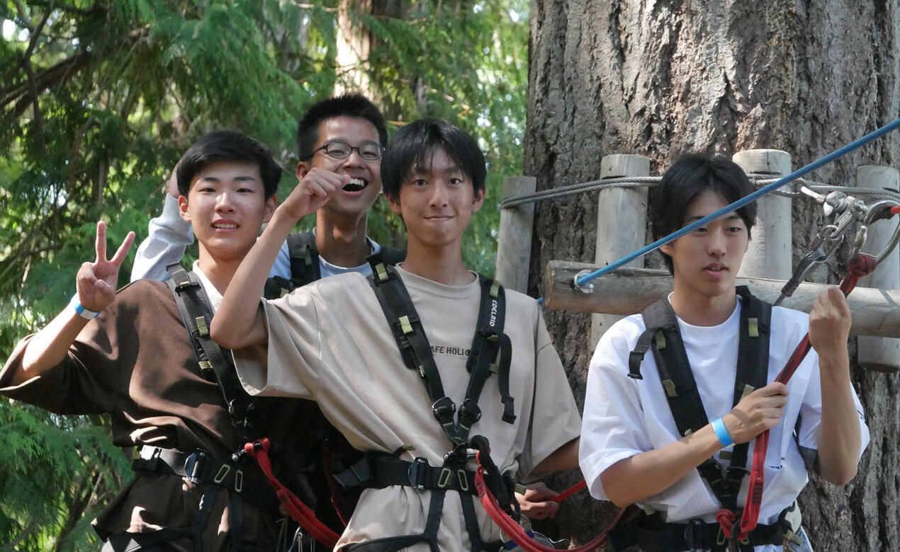 Students ziplining through the trees