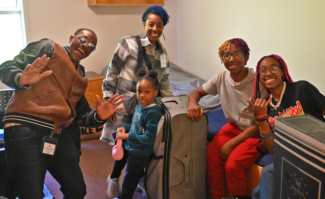 A family helps their child settle into a boarding room