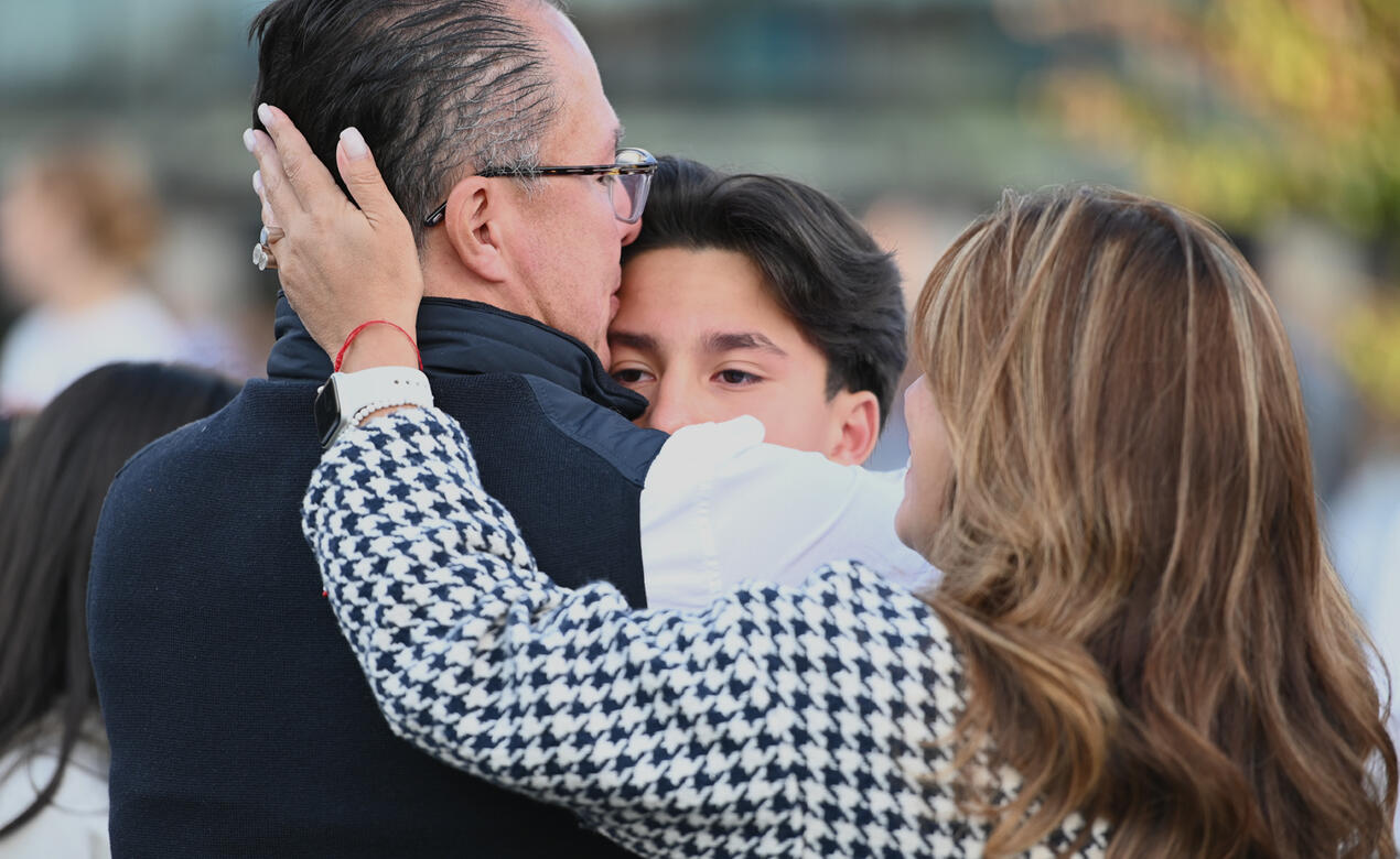 Parents give heartfelt hugs to their child at the new boarder orientation
