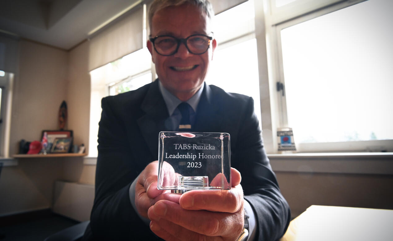 A photo of Mark Turner holding his award