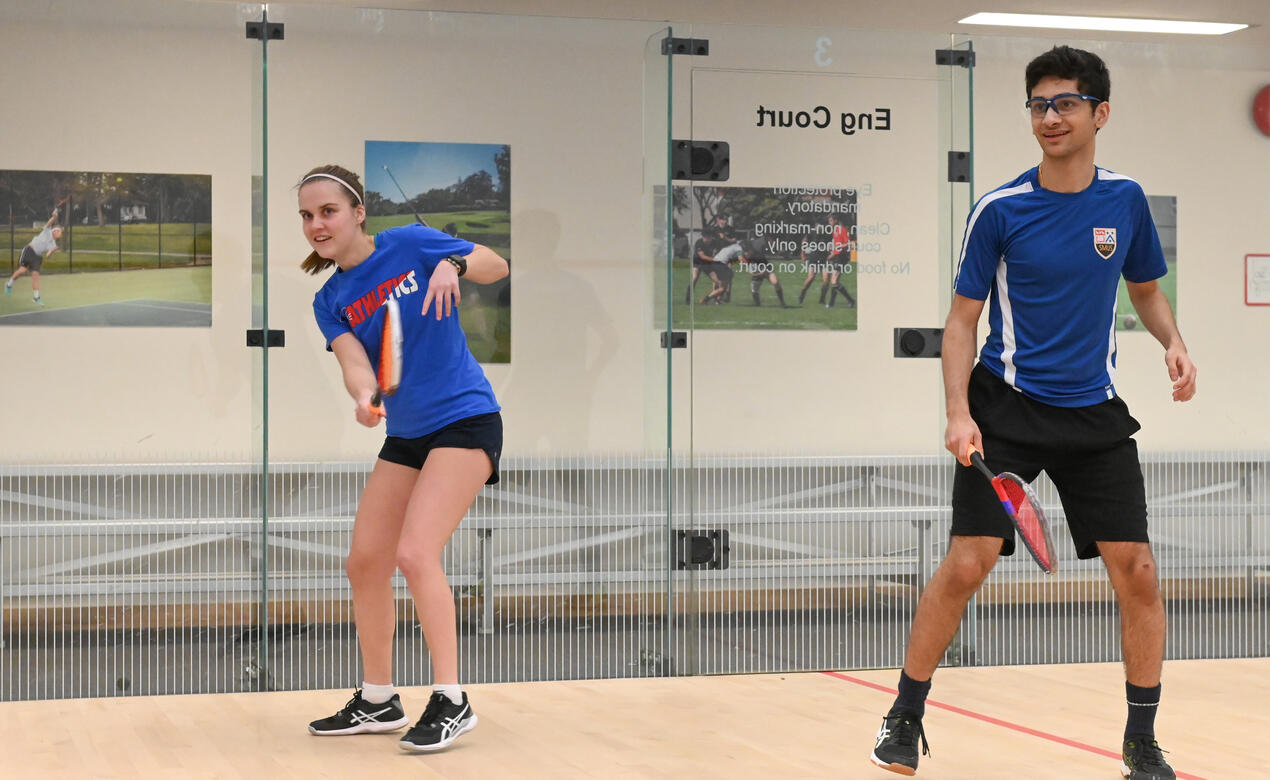 Grace and Roshan follow the ball in a game of squash 