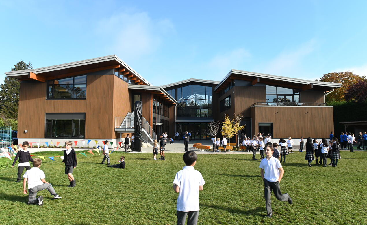 Students play on the field behind the Annex