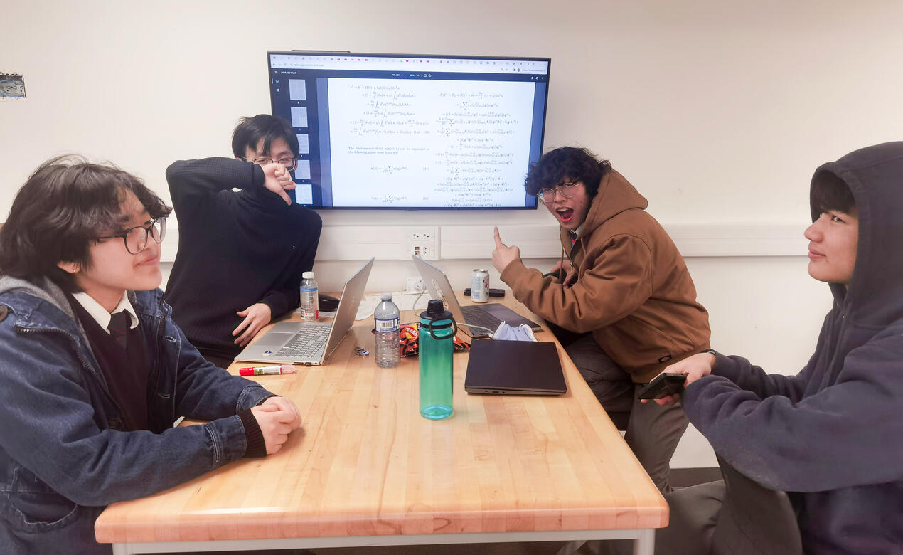 Four students work on a physics match