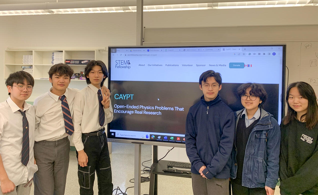 The CaYPT team stand next to a large computer screen