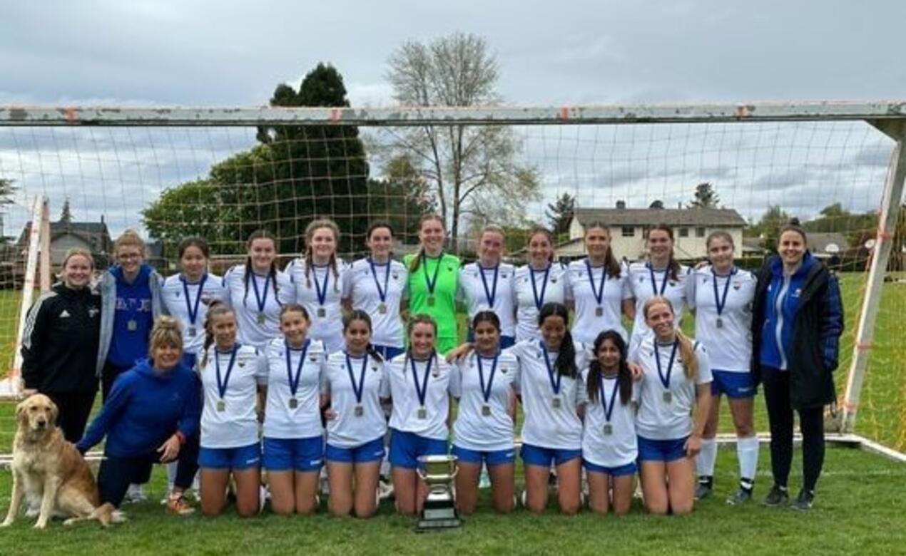 The team and coaches pose for a photo with their medals