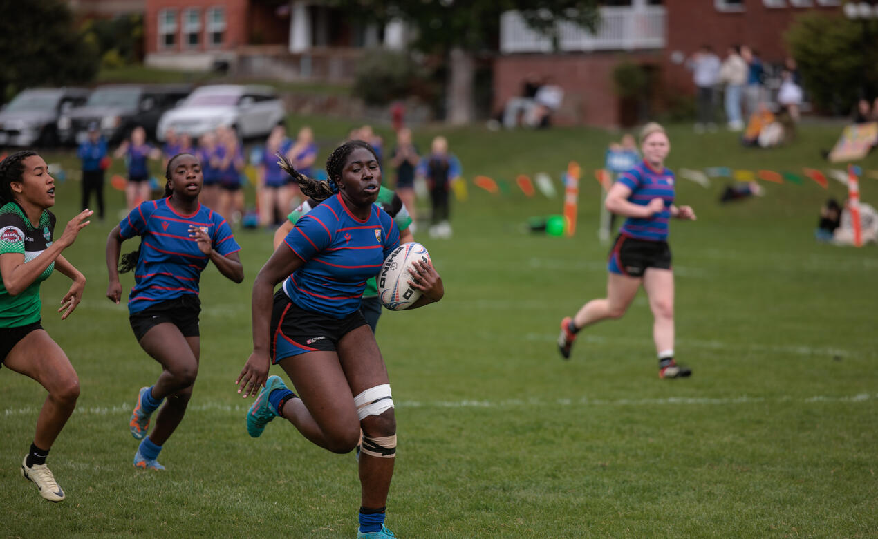 A rugby player runs with the ball