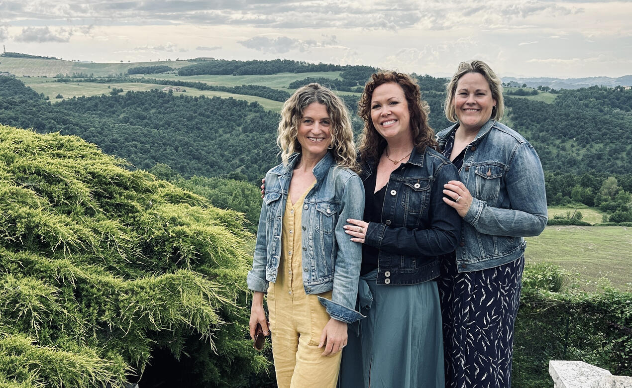 Three Junior Kindergarten teachers pose with a picturesque Italian view while at the Reggio conference in Italy.