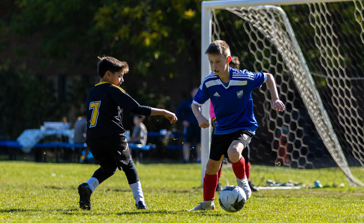 A SMUS player dribbles and evades a defender