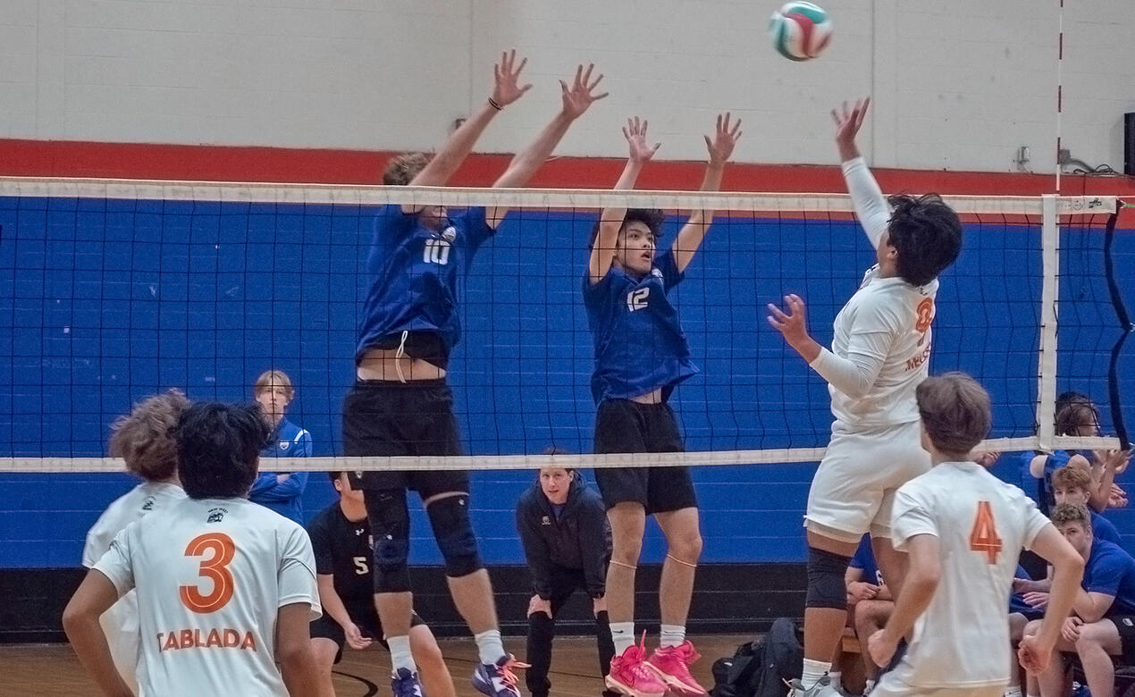 2 players defend a smash at the net
