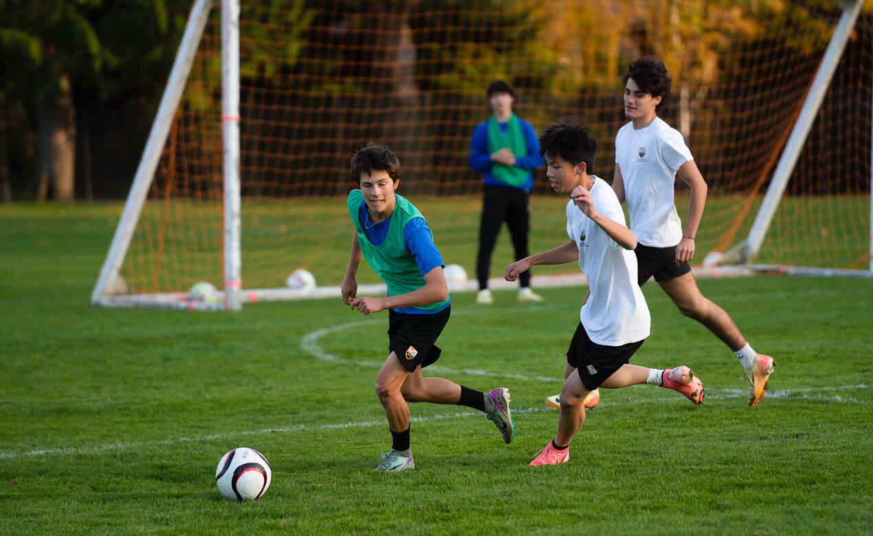 3 boys practice their skills on the field