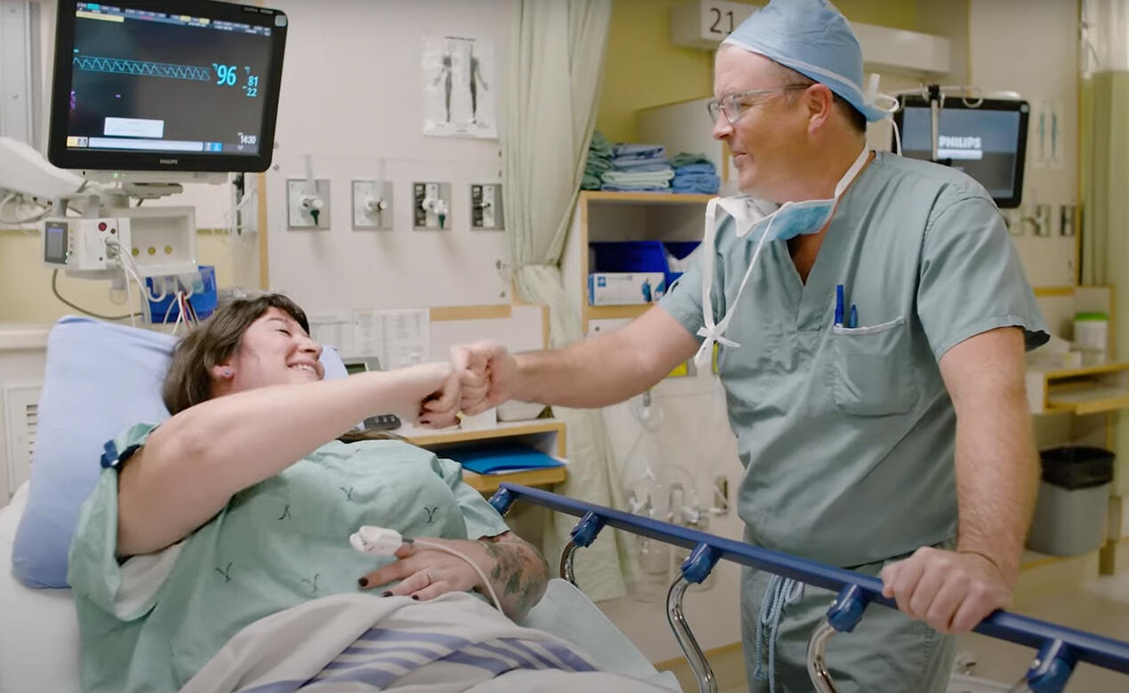Alumni Jeff McCracken with patient in hospital