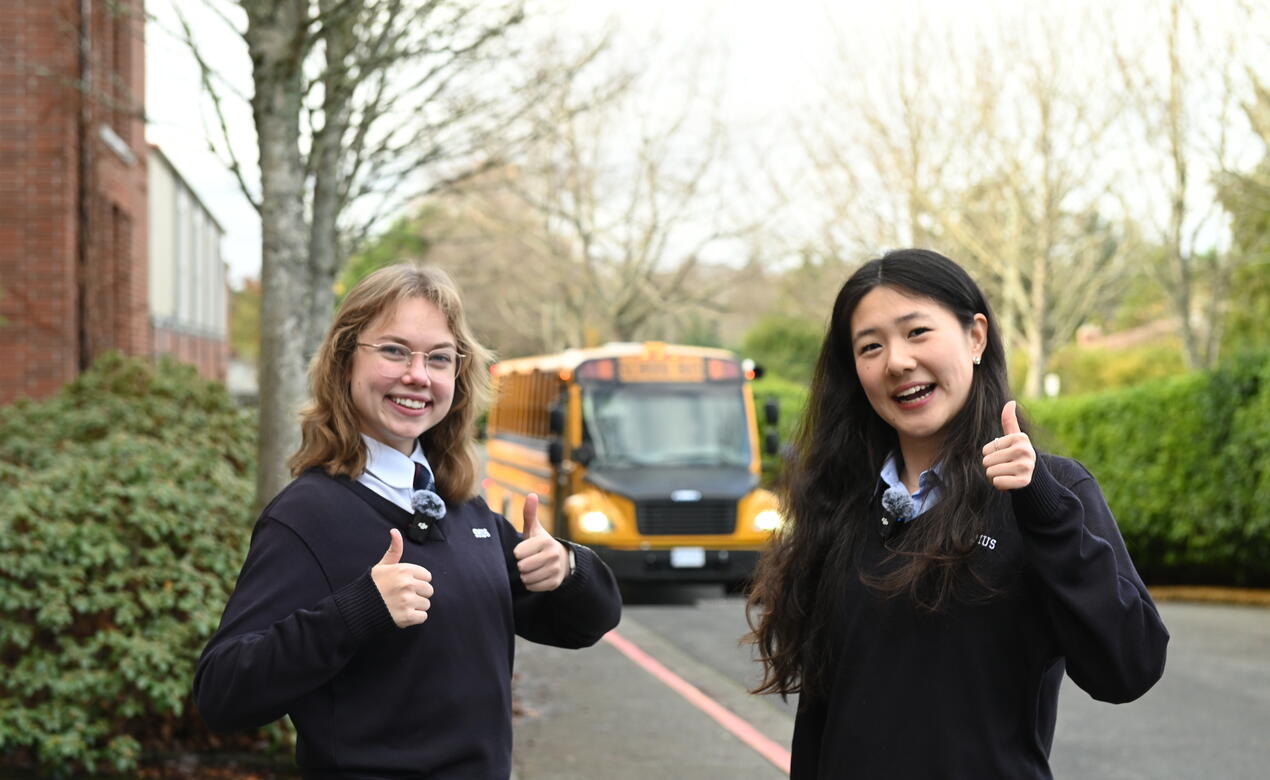 Larissa Zhao Beatrice Sharpe give a thumbs up as the new electric bus pulls up to campus for the first time.