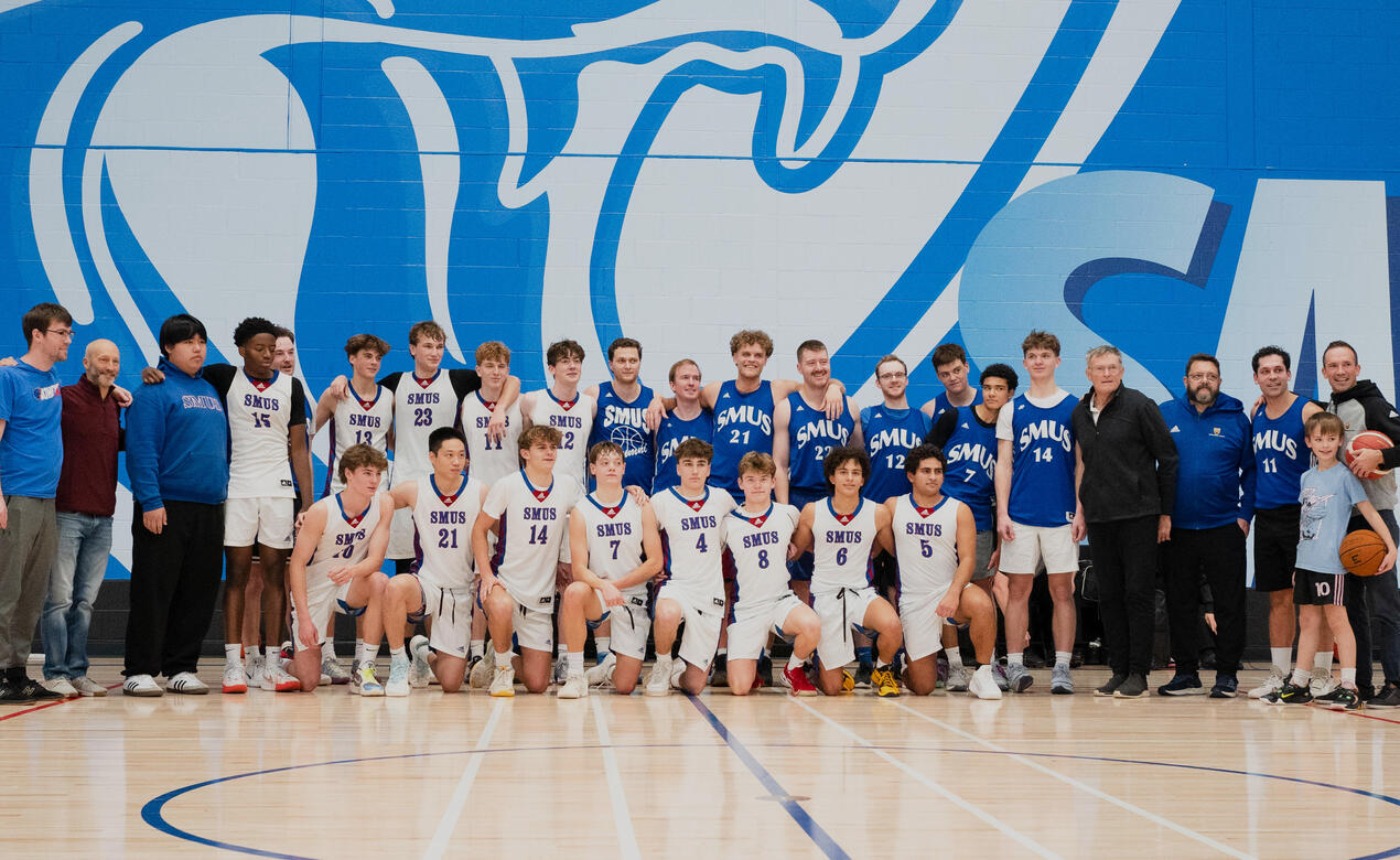 The Senior Boys Basketball gather for a group photo with the Alumni team